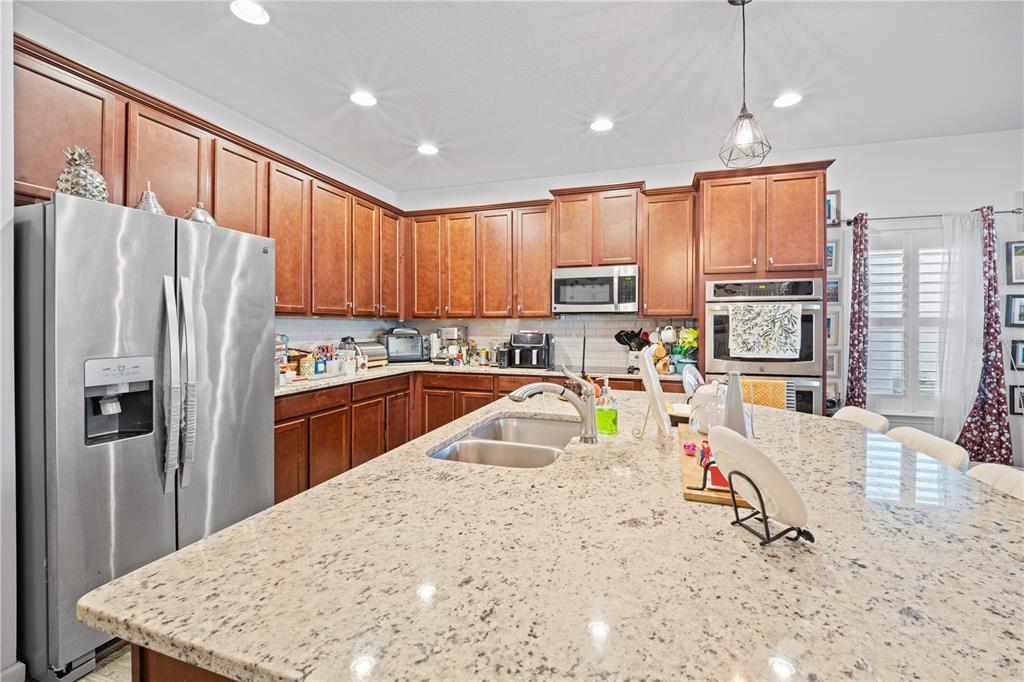 1722 Reflection Lane St. Cloud, FL 34771 - Photo 12 of 26 a kitchen with stainless steel appliances granite countertop a refrigerator a stove top oven a sink and dishwasher