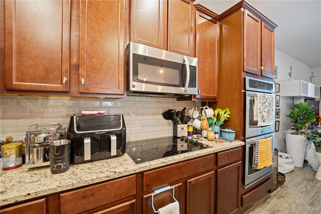 1722 Reflection Lane St. Cloud, FL 34771 - Photo 13 of 26 a kitchen with granite countertop a stove a sink and a microwave