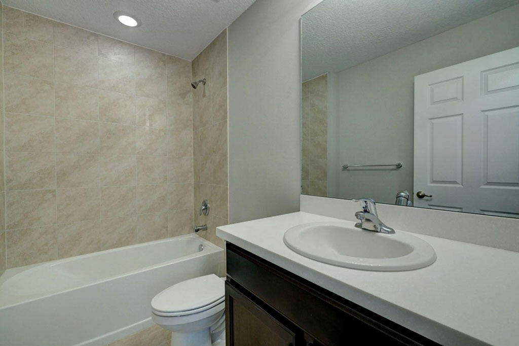 3773 Southwest Swope Street Port St. Lucie, FL 34953 - Photo 8 of 11 a bathroom with a sink toilet and a bathtub