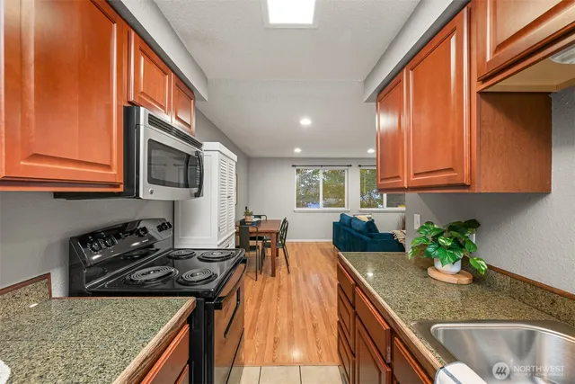 a kitchen with granite countertop stainless steel appliances window a sink and cabinets