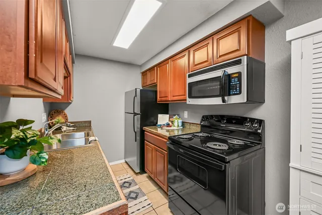 a kitchen with stainless steel appliances granite countertop a stove a sink and a microwave