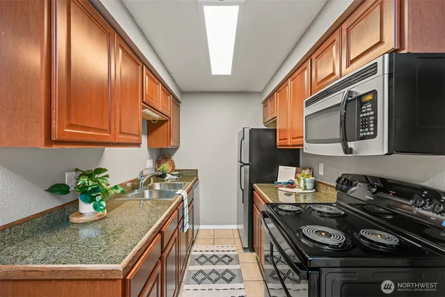 a kitchen with stainless steel appliances granite countertop a stove a sink dishwasher and cabinets