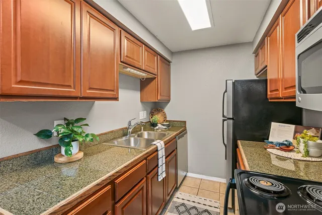 a kitchen with stainless steel appliances granite countertop sink stove and refrigerator