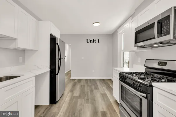 a kitchen with stainless steel appliances a refrigerator and a stove top oven