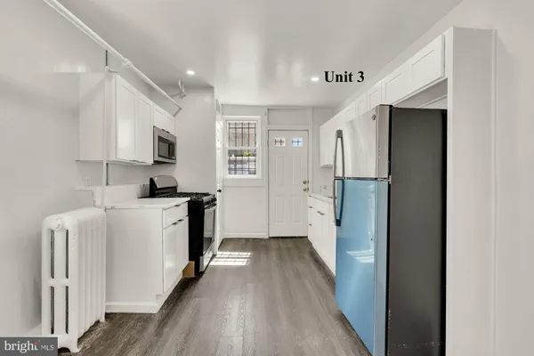 a view of a big room with wooden floor and windows