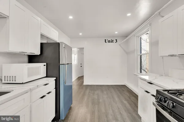 an empty room with wooden floor and window