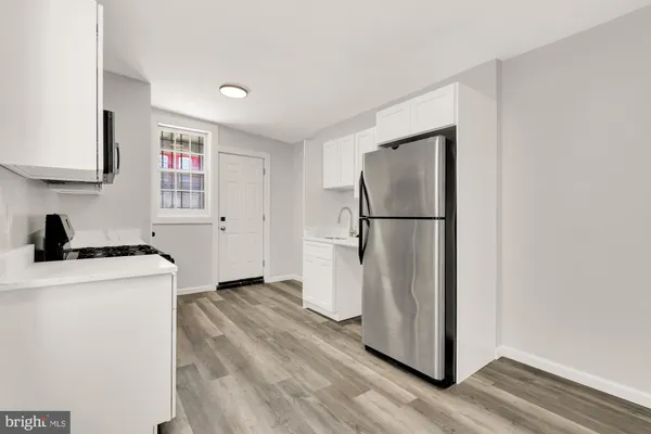 a kitchen with stainless steel appliances a stove a microwave and white cabinets