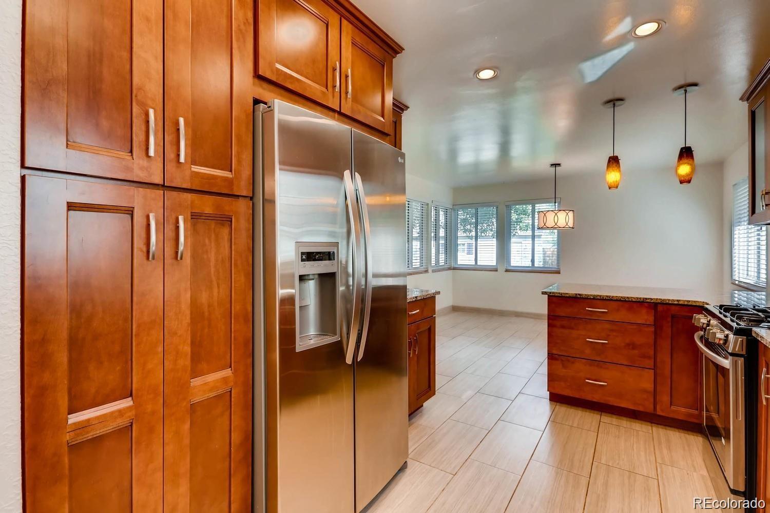 1610 South Cook Street Denver, CO 80210 - Photo 7 of 37 a kitchen with stainless steel appliances granite countertop a refrigerator a stove and a cabinets with wooden floor