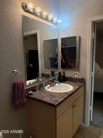 a bathroom with a granite countertop sink a large mirror and a shower