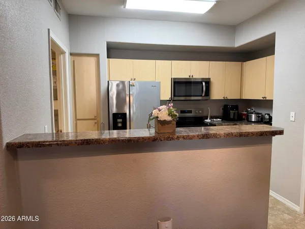 a living room with stainless steel appliances granite countertop a stove a refrigerator a sink and a microwave oven