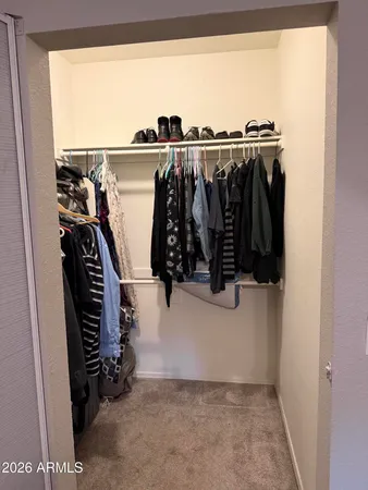 a view of walk in closet with clothes and shoes