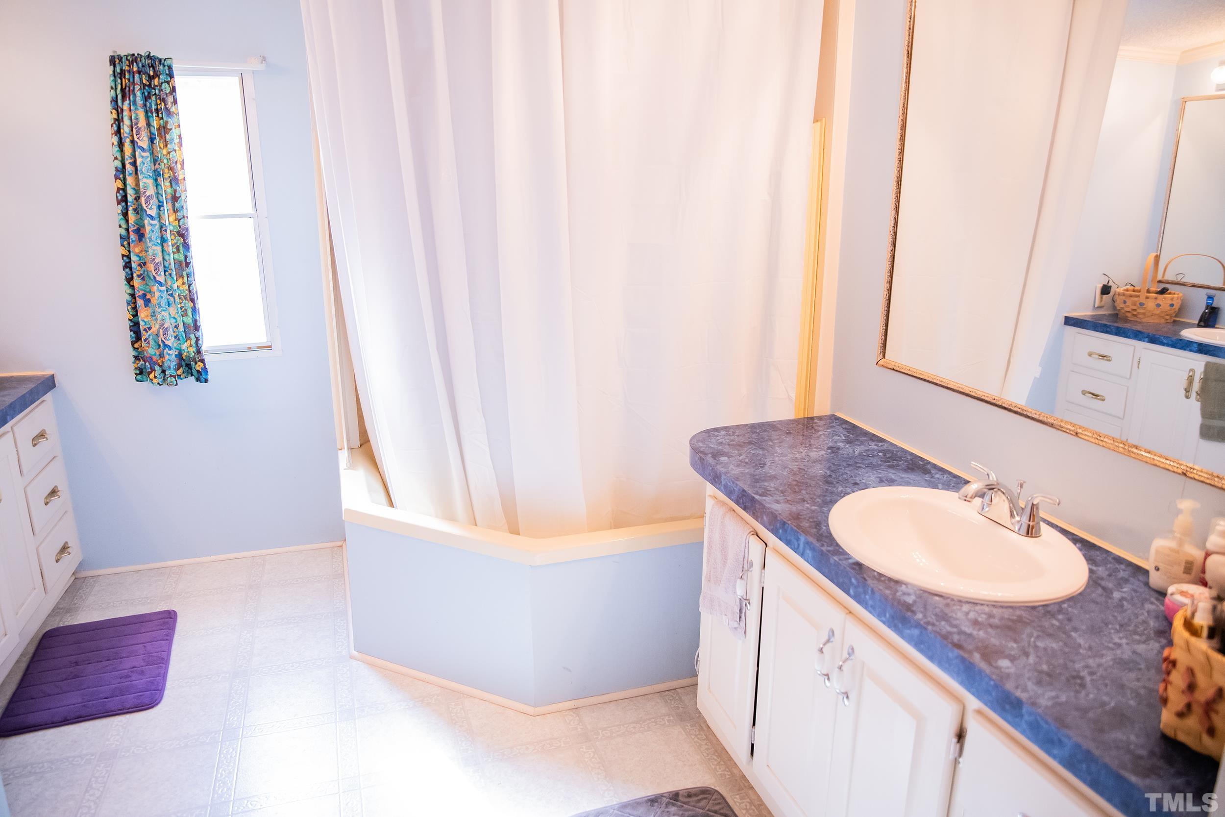 6180 Helena Moriah Road Rougemont, NC 27572 - Photo 23 of 41 a bathroom with a granite countertop sink and a mirror
