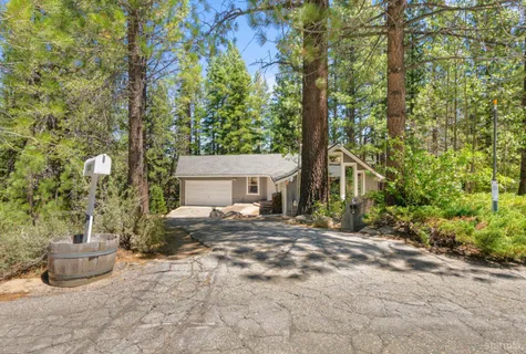 a view of a house with backyard and a tree