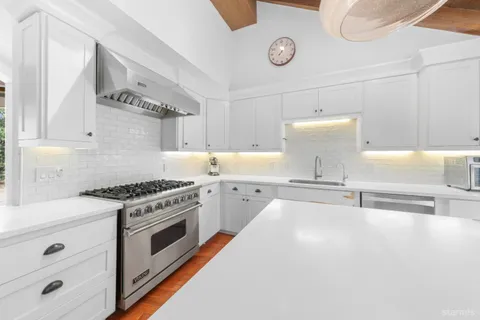 a kitchen with a sink a refrigerator and cabinets