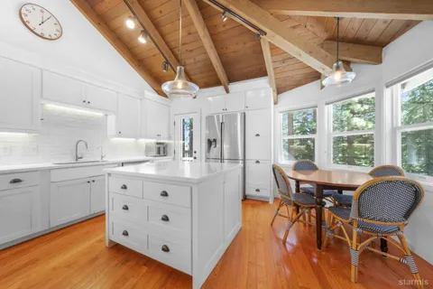 a kitchen with granite countertop a sink a stove and cabinets