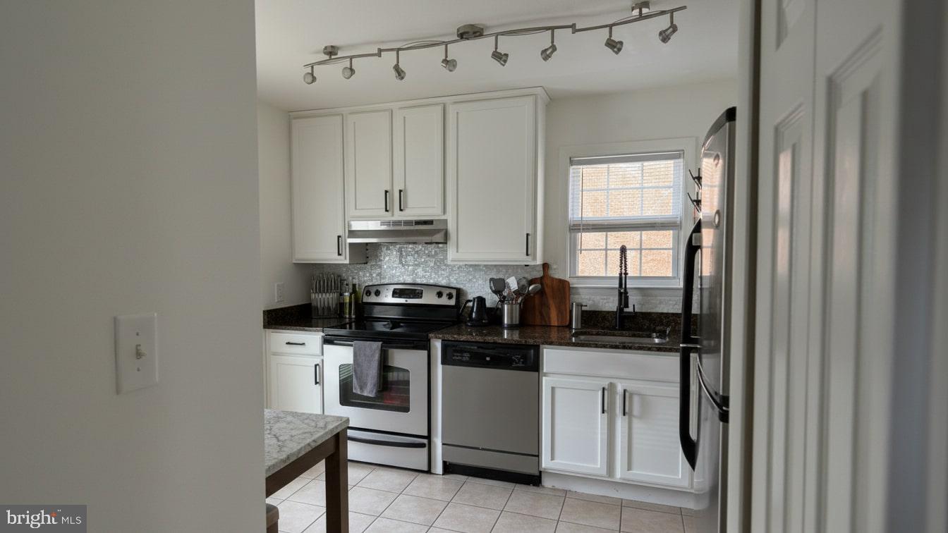 16031 Dorset Road, Unit 161 Laurel, MD 20707 - Photo 14 of 25 a kitchen with stainless steel appliances a stove a sink and white cabinets