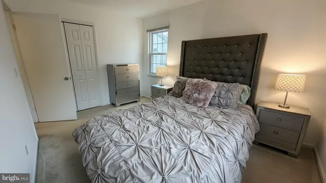 a bedroom with a bed and a lamp on dresser