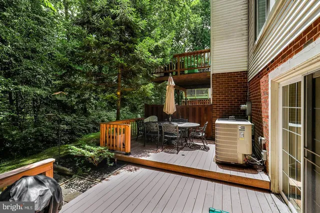 a view of couches and a patio with table and chairs with wooden floor and fence