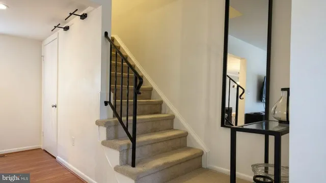 a view of staircase with wooden floor and white walls