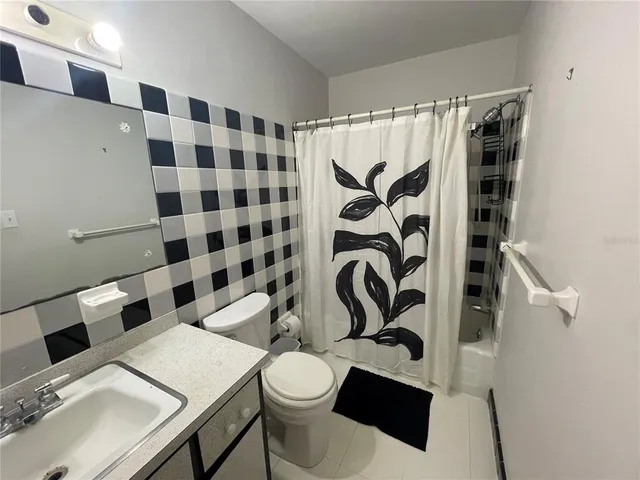 a bathroom with a sink a toilet and shower curtain