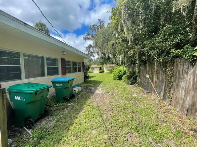 a view of a house with backyard and sitting area