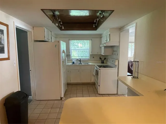 a kitchen with a sink a refrigerator and cabinets