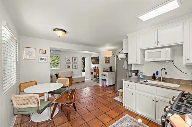 a kitchen with a dining table chairs and white cabinets
