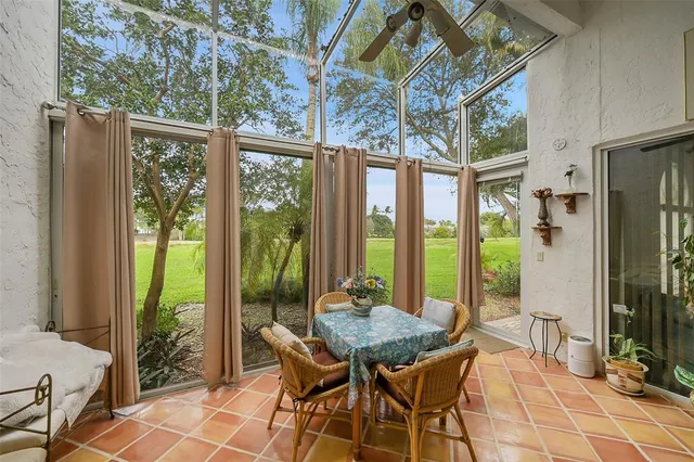 a spacious bedroom with a large bed a chandelier and windows