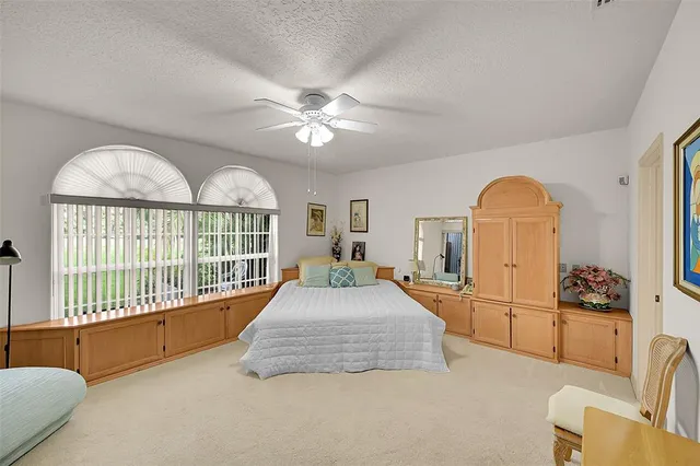 a bedroom with a large bed and a chandelier