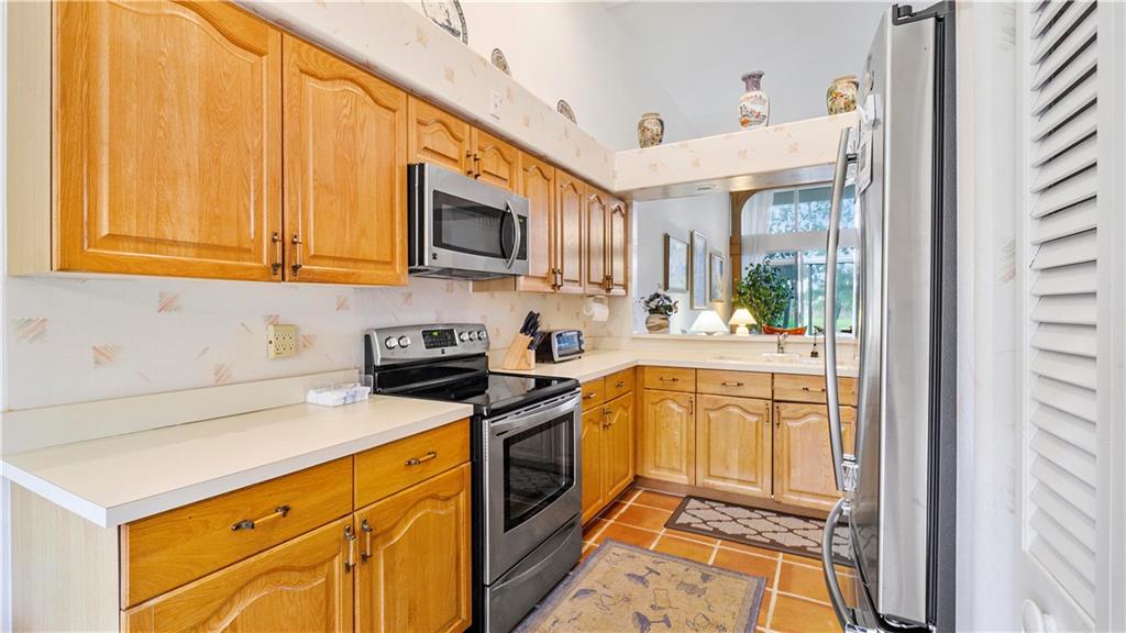 17210 Boca Club Boulevard, Unit 103 Boca Raton, FL 33487 - Photo 5 of 15 a kitchen with stainless steel appliances granite countertop a stove a sink and a microwave