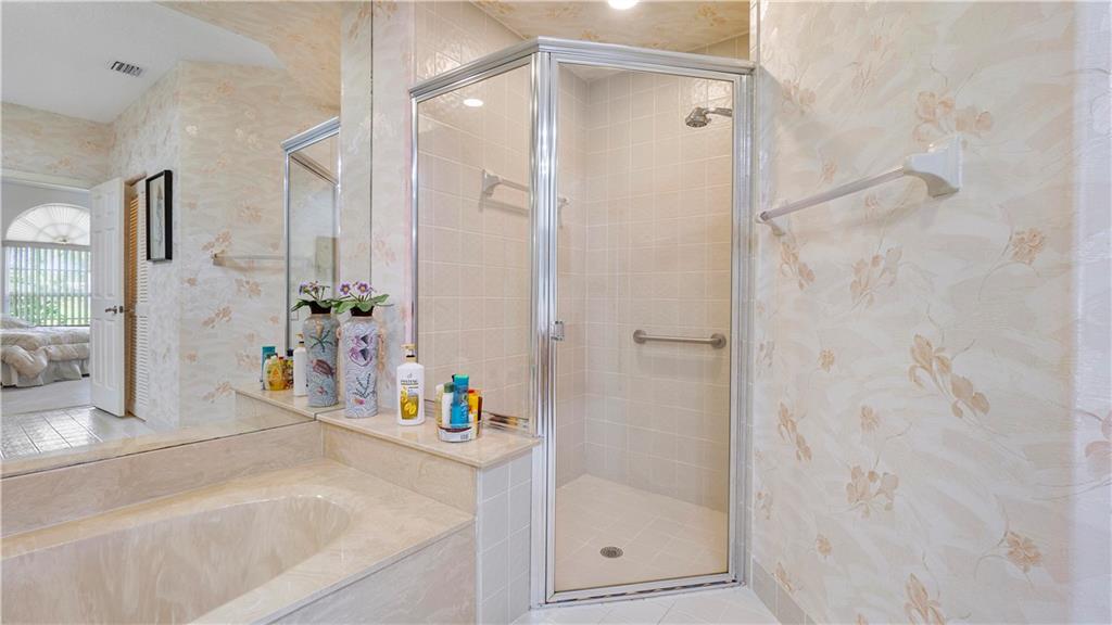 17210 Boca Club Boulevard, Unit 103 Boca Raton, FL 33487 - Photo 9 of 15 a bathroom with a tub shower and mirror