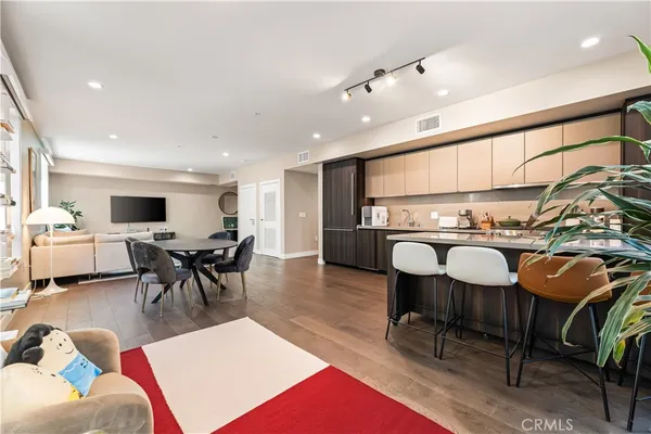 a living room with furniture a rug and kitchen view