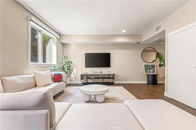 a living room with furniture a flat screen tv and a window