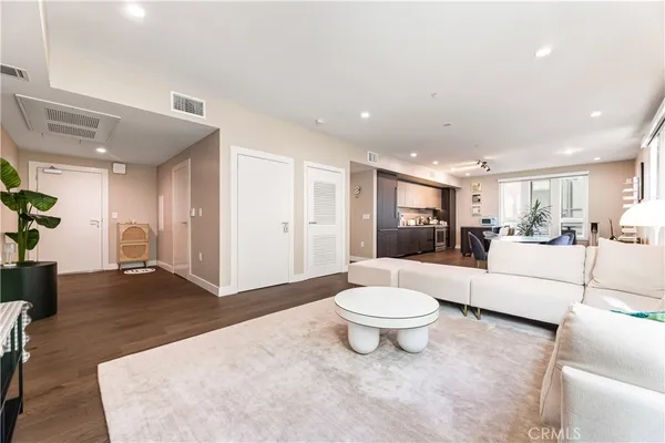 a living room with furniture a mirror and a potted plant
