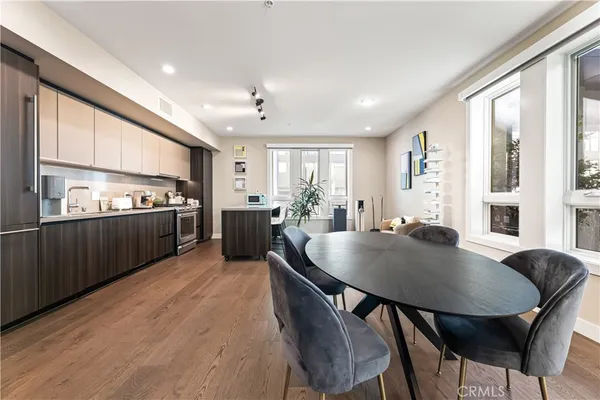 a living room with stainless steel appliances kitchen island granite countertop furniture and wooden floor