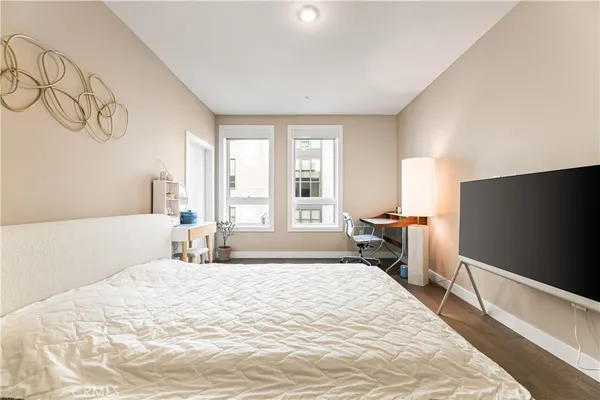 a bedroom with a bed and a flat tv screen on the dresser