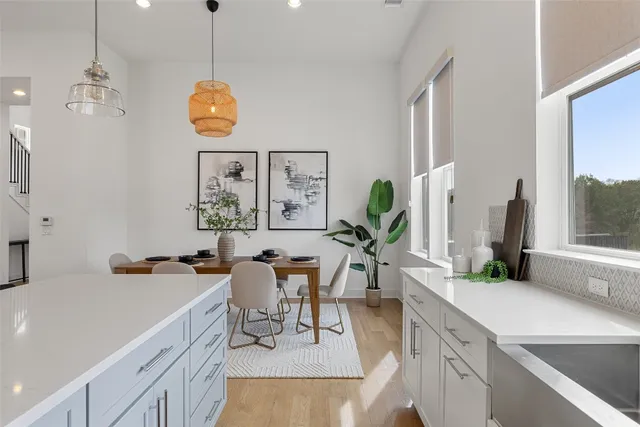 a large kitchen with stainless steel appliances kitchen island white cabinets and wooden floor