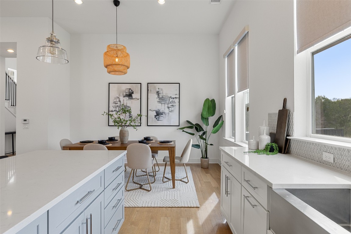 4400 Night Owl Lane Austin, TX 78723 - Photo 11 of 40 a view of a dining room and a sink wooden floor windows and a chandelier