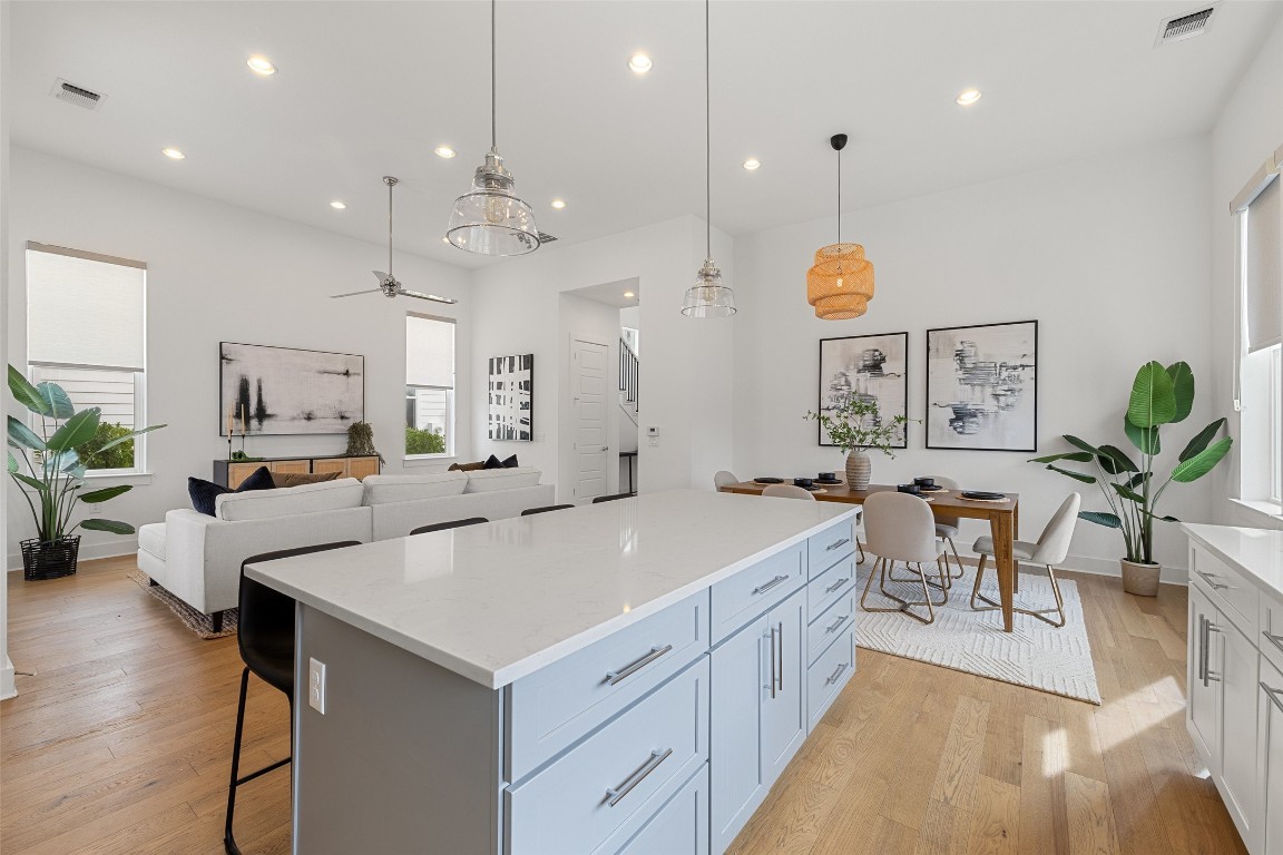 4400 Night Owl Lane Austin, TX 78723 - Photo 13 of 40 a large white kitchen with lots of counter space and painting on the wall
