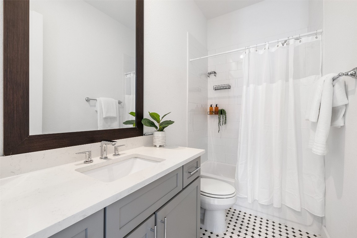 4400 Night Owl Lane Austin, TX 78723 - Photo 32 of 40 a bathroom with a sink a toilet and shower curtain