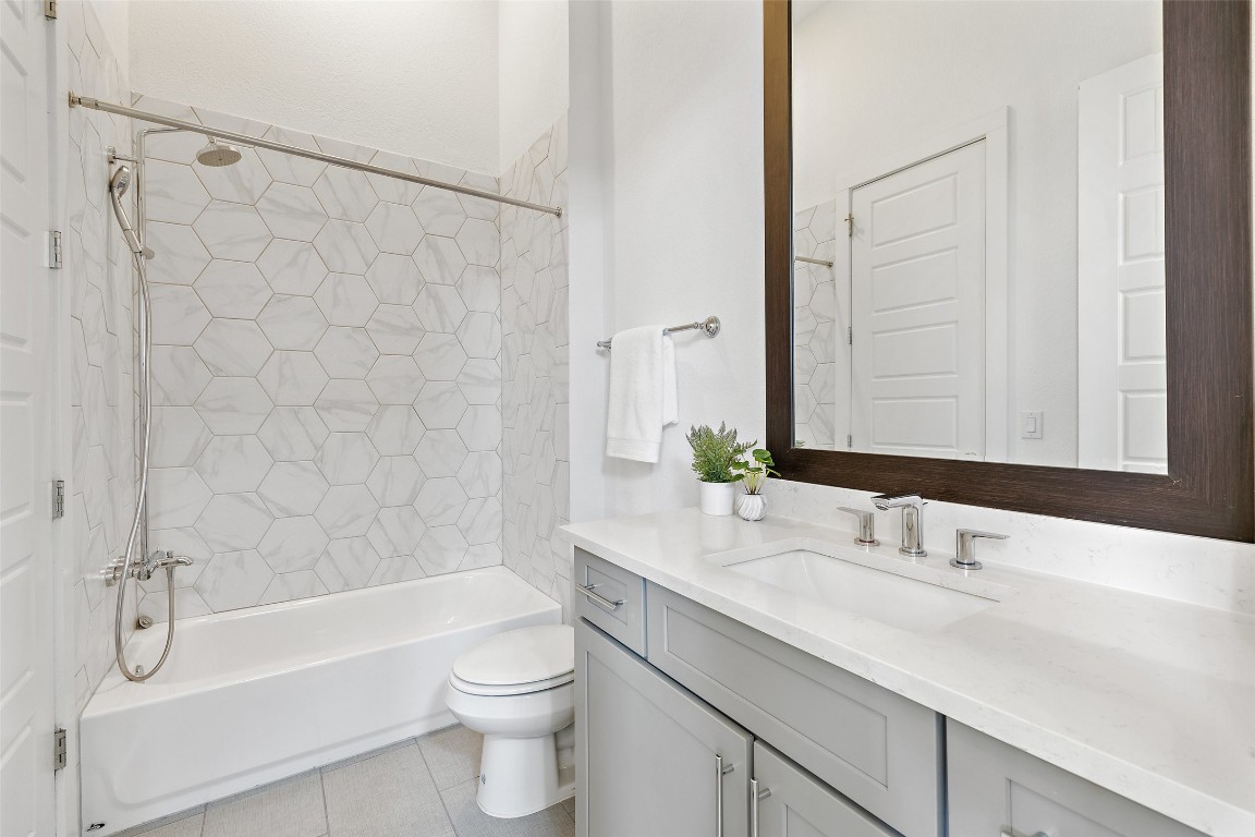 4400 Night Owl Lane Austin, TX 78723 - Photo 33 of 40 a bathroom with a granite countertop sink a toilet and a bathtub