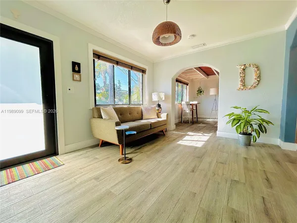 a living room with patio furniture and a large window
