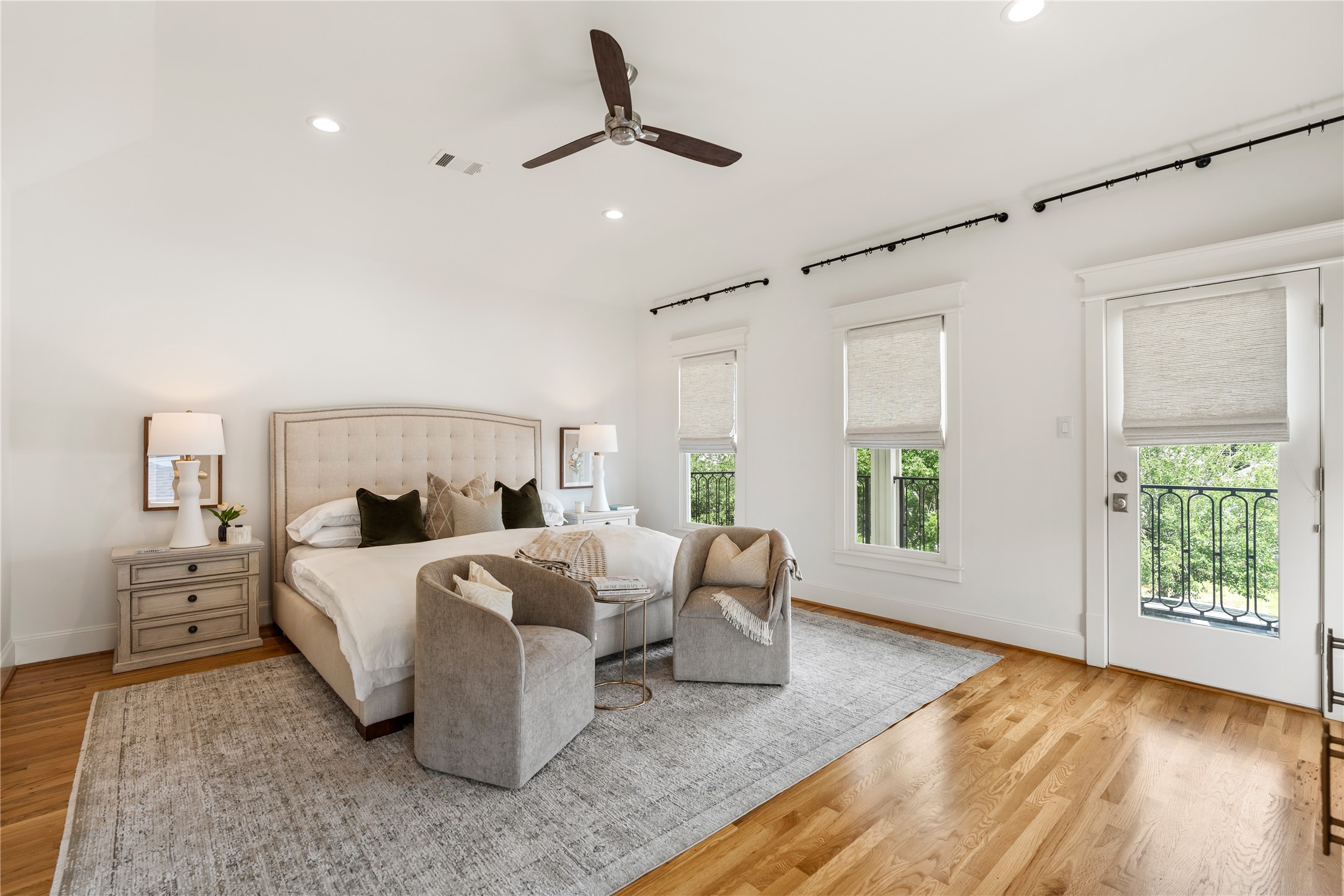 925 Tulane Street, Unit A Houston, TX 77008 - Photo 36 of 49 Sleep soundly in the primary suite where a row of windows and a glass door are trimmed with Roman shades and custom hanging rods.