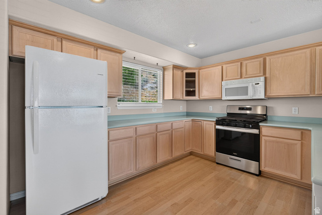 1305 Alpine Way Provo, UT 84606 - Photo 19 of 56 Kitchen featuring light wood cabinetry, light-toned countertops, stainless steel gas range, and wood-finish flooring