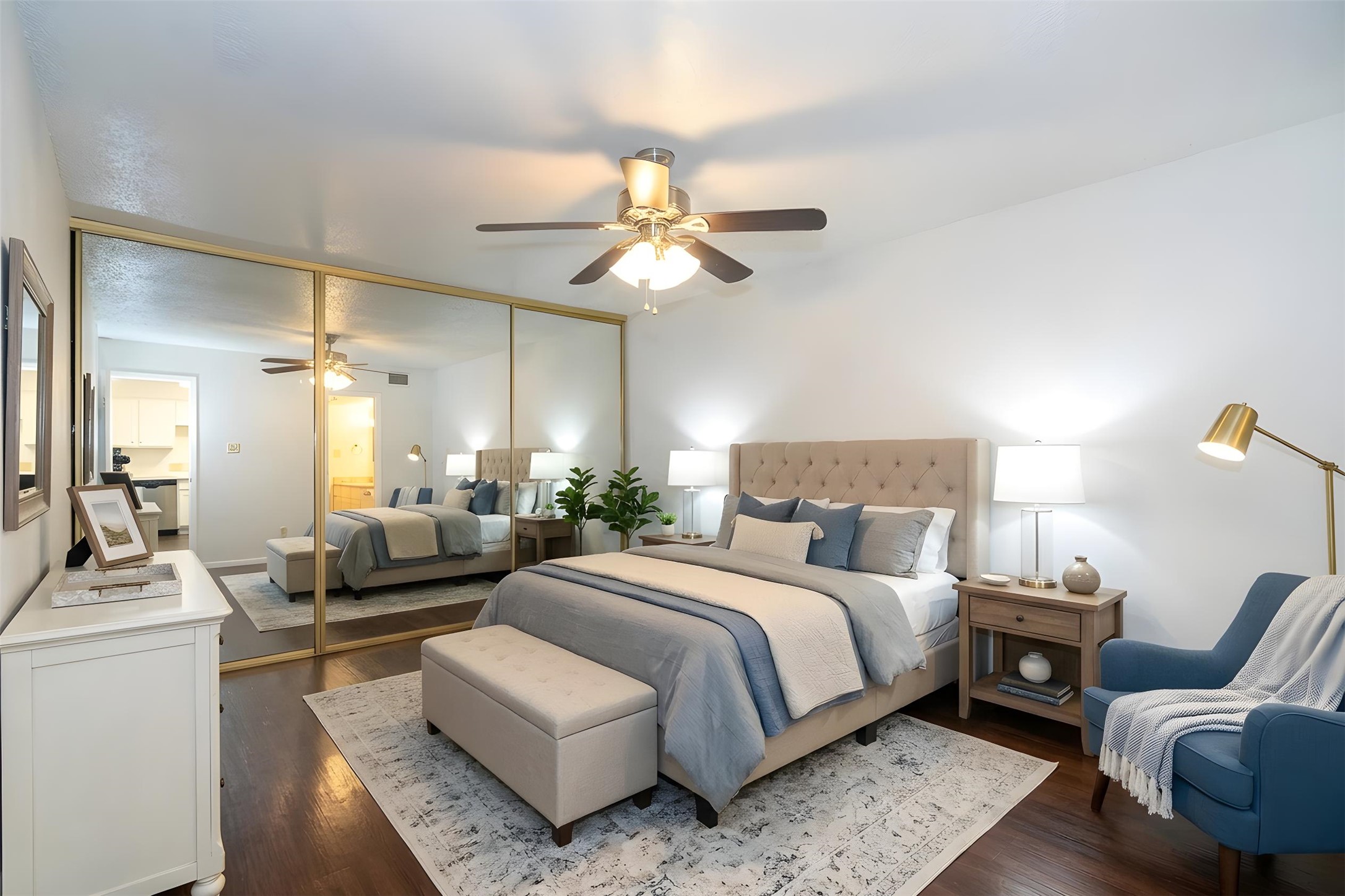 3115 Helms Street, Unit 106 Austin, TX 78705 - Photo 6 of 7 Hardwood-look floors and generous mirrored closet doors define this primary bedroom retreat.