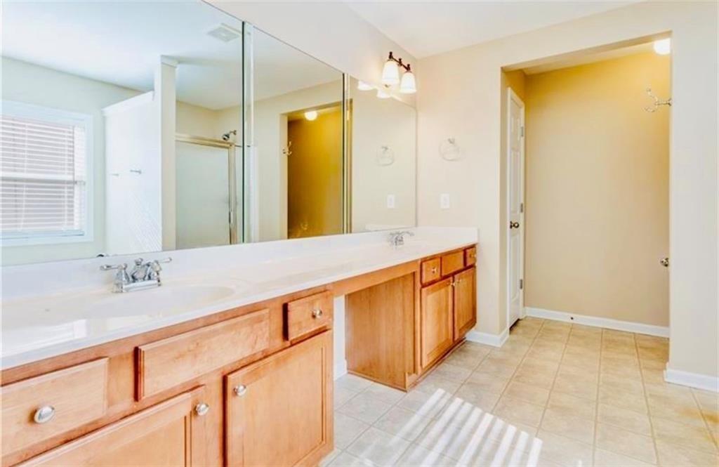 5430 Crestwick Way Cumming, GA 30040 - Photo 13 of 23 a spacious bathroom with a granite countertop sink and a large mirror