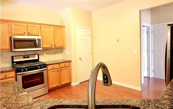 a kitchen with stainless steel appliances granite countertop a stove a microwave and a refrigerator