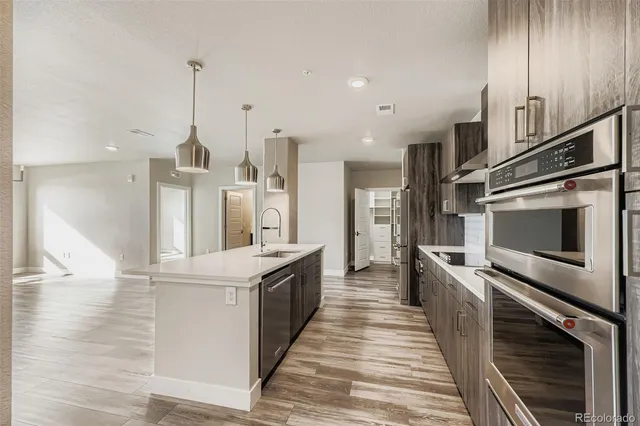 a large kitchen with stainless steel appliances kitchen island granite countertop a stove and a sink