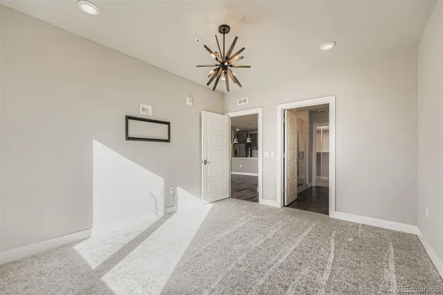 a view of a hallway with closet and a chandelier fan