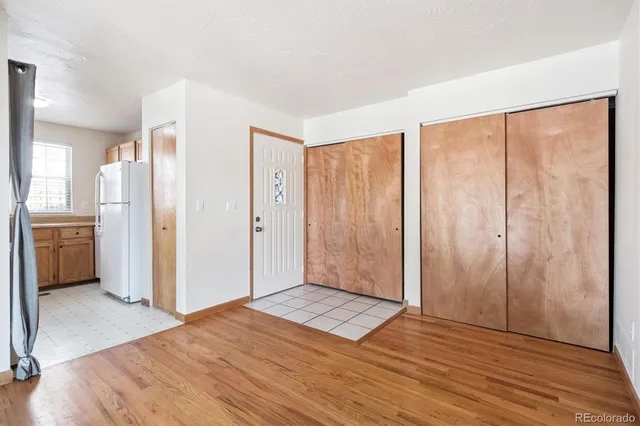 a view of a big room with wooden floor and windows